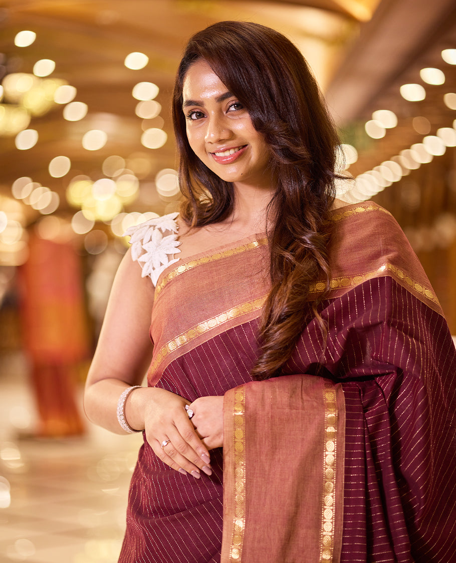 Deep maroon colour Kanchi cotton saree featuring antique zari stripes on the body, traditional temple borders, a grand pallu, and paired with a matching blouse