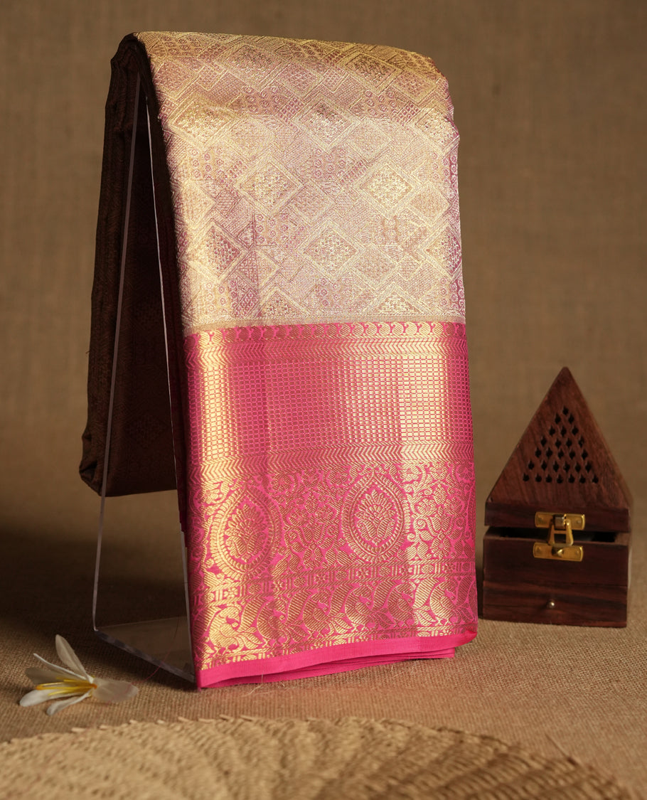 Golden Colour Kancheepuram tissue silk saree featuring intricate silver and pink Zari diamond motifs on the body, beautifully complemented by a contrasting traditional peacock and floral kodi design border, paired with a matching blouse.