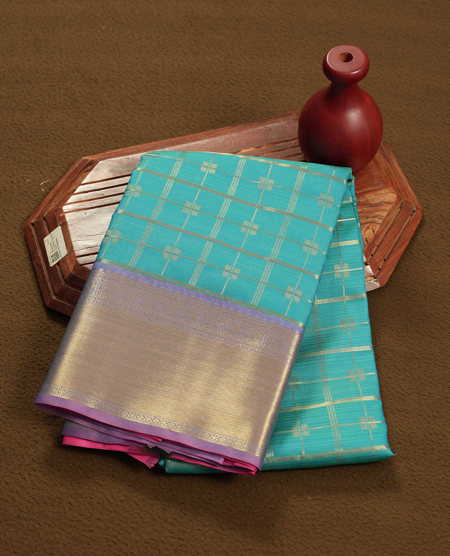 Aqua blue colour semi soft silk saree featuring a gold zari textured patterned body, complemented by contrast pink colour gold zari motifes on pallu & border and a matching blouse piece.
