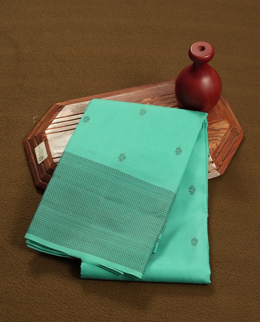 Aqua green colour semi soft silk saree featuring a gray textured patterned body, complemented by self coloured gray zari on pallu & border and a matching blouse piece.