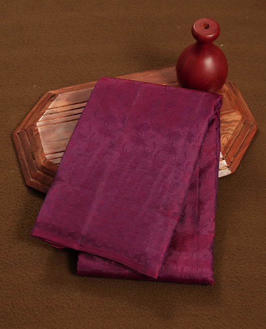 Wine colour semi soft silk saree featuring a self coloured textured patterned body, complemented by self coloured motifes on pallu & border and a matching blouse piece.