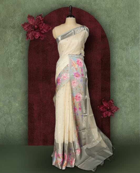 Ivory colour Kotta Tussar Silk saree features a vibrant digital floral print with small gold zari motifs on the body, and elegant blue colour banarasi border & Paired with a matching blouse,blending modern design with traditional elegance.