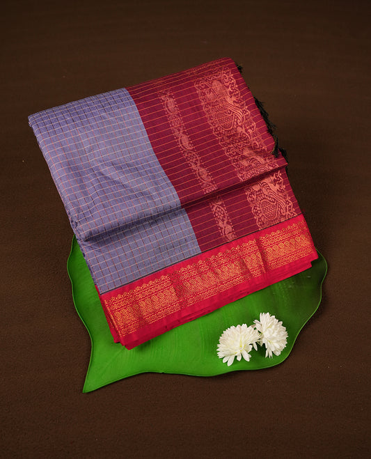 Lavender coloured mixed Kalyani cotton saree featuring copper zari checks on the body, complemented by a red coloured border and burnt red colourpallu adorned with copper zari patterns, Paired with a matching blouse.