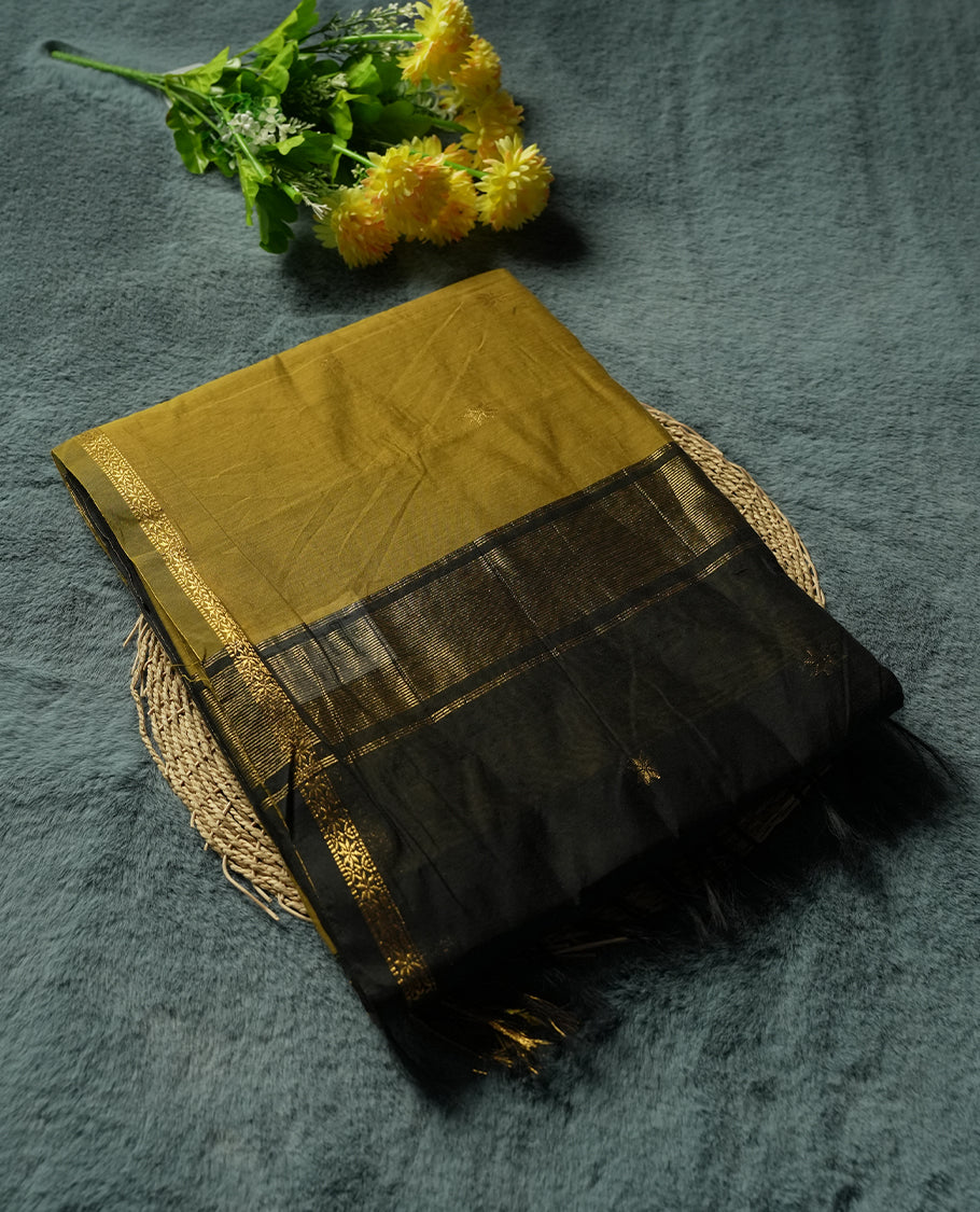 Mustard Yellow and Charcoal Black Colour silk-cotton saree with tiny zari star buttas, black pallu with pinstripes and buttas, slim antique-gold borders, and a plain black blouse accented with matching zari border