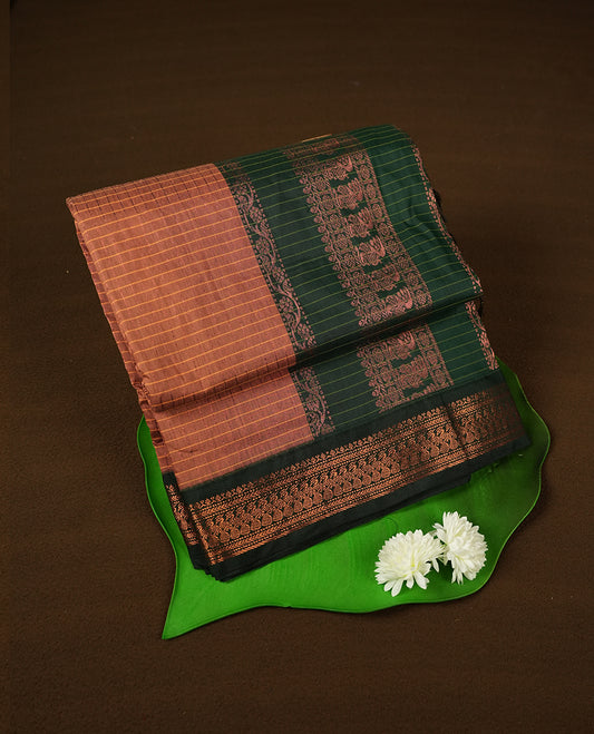 copper coloured mixed Kalyani cotton saree featuring copper zari checks on the body, complemented by a dark green coloured border and pallu adorned with copper zari patterns, Paired with a matching blouse.