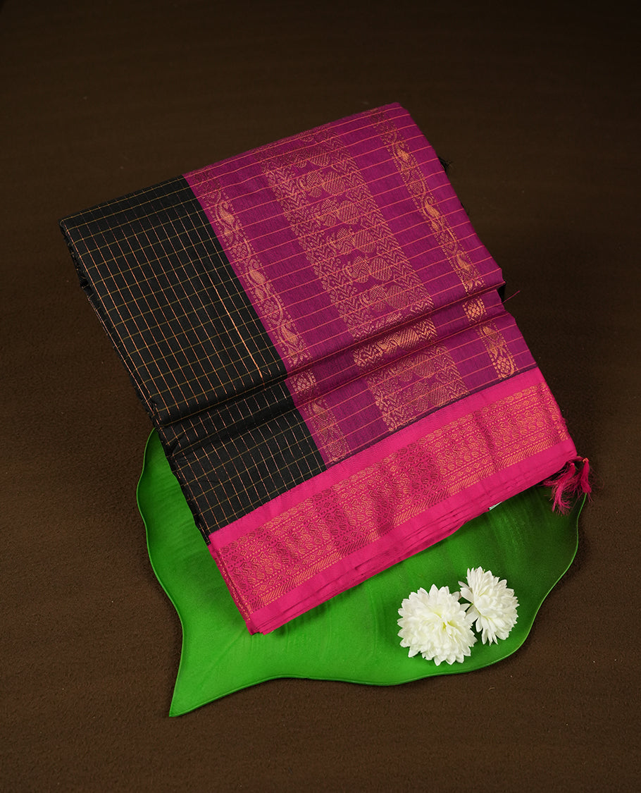 Black coloured mixed Kalyani cotton saree featuring copper zari checks on the body, complemented by a dark magenta coloured border and pallu adorned with copper zari patterns, Paired with a matching blouse.