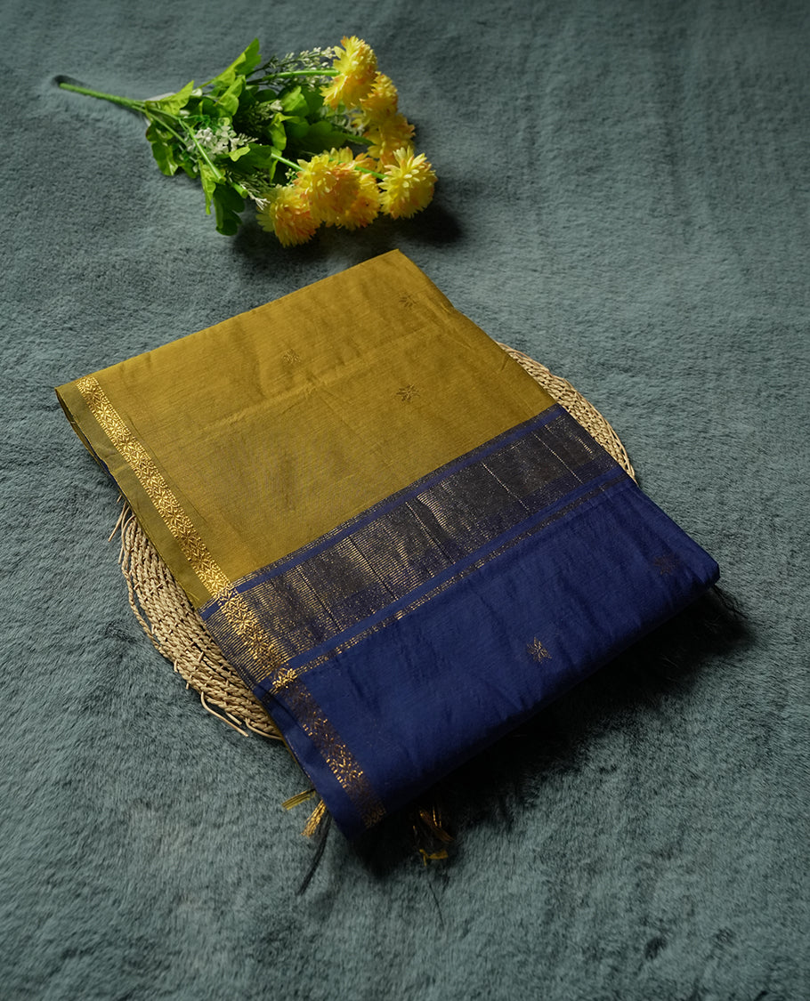 Mustard Yellow and Royal Blue Colour silk cotton saree with tiny zari star buttas, blue pallu with pinstripes and scattered buttas, slim antique-gold borders, and a plain blue blouse with matching zari edging.