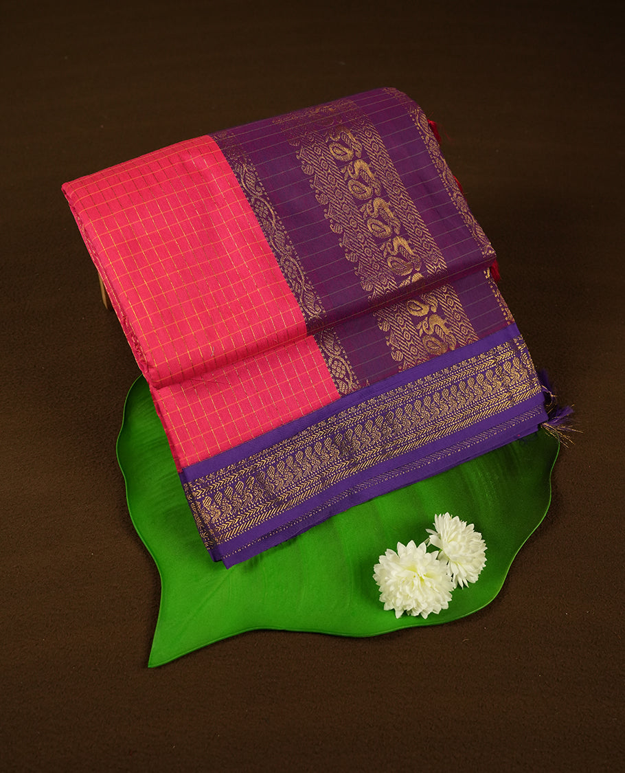 bright pink coloured mixed Kalyani cotton saree featuring golden zari checks on the body, complemented by a Dark Purple coloured border and pallu adorned with golden zari patterns, Paired with a matching blouse.