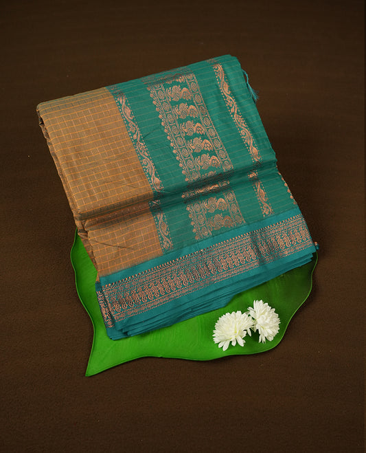 Mustard yellow coloured mixed Kalyani cotton saree featuring copper zari checks on the body, complemented by a dusty green coloured border and pallu adorned with copper zari patterns, Paired with a matching blouse.