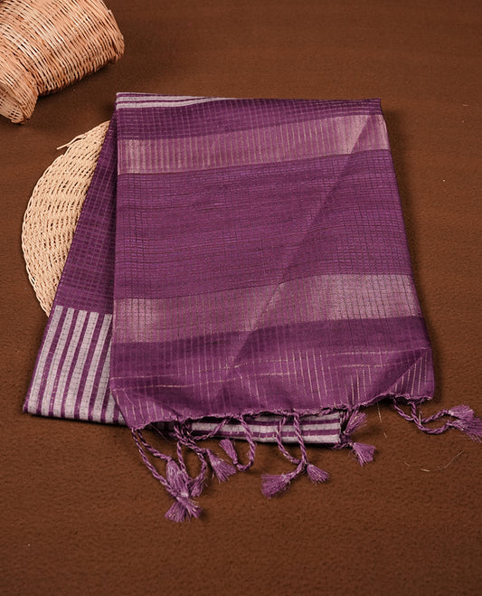 Purple colour semi tussar silk saree featuring zari check pattern across body, self colour border and geometric pattern pallu, paired with matching blouse piece.