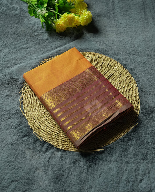 Marigold colour Silk Cotton Saree with Rich Maroon Zari Borders Showcasing Traditional Peacock and Floral Panels, Multiple Horizontal Zari Lines on the Pallu, and a Coordinated Matching Blouse Piece