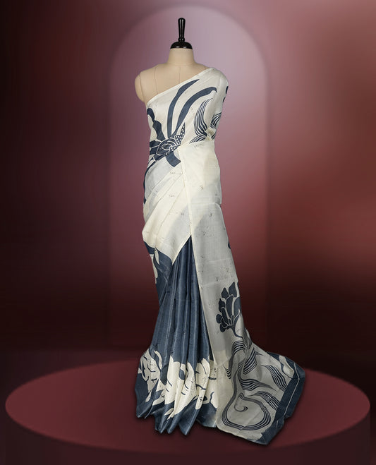 Grey and off white colour saree featuring bold floral and abstract prints across the body and pallu, offering a perfect blend of elegance and modern style, paired with a matching blouse piece.