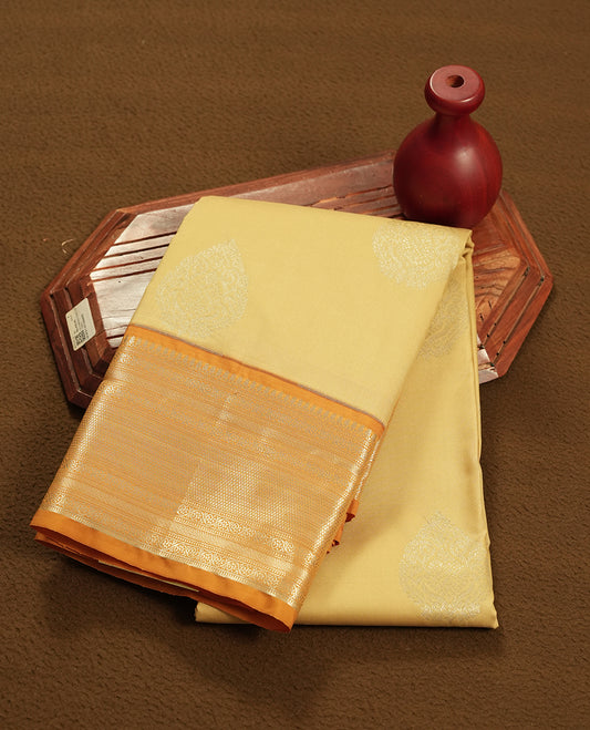 Muted yellow colour semi soft silk saree featuring a gold zari motifs on body, complemented by contrast mustard colour with gold traditional  pallu & border and a matching blouse piece.