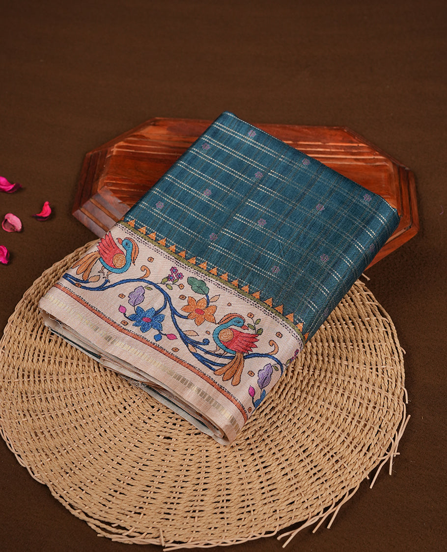 Dark green colour semi tusser silk saree featuring gold zari check pattern with floral butti motifs, with contrast floral kodi & bird pattern and paired with matching blouse.