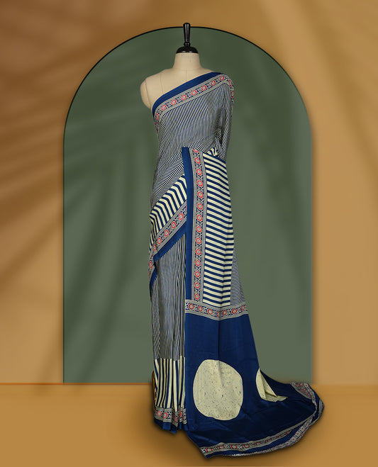 Navy blue and cream colour saree with fine vertical stripes and traditional floral borders & A bold circular motif enhances the pallu, giving it a contemporary twist, Lightweight and graceful, paired with matching blouse.