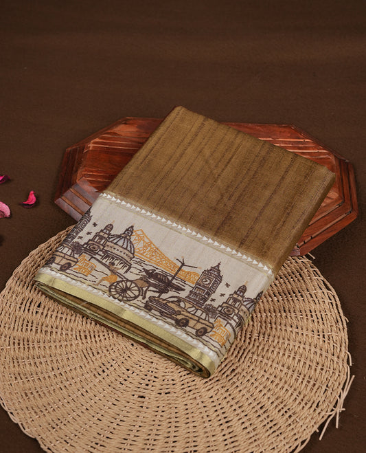 Khaki colour semi tusser silk saree featuring contrast cream colour London bridge printed pattern border and paired with matching blouse.