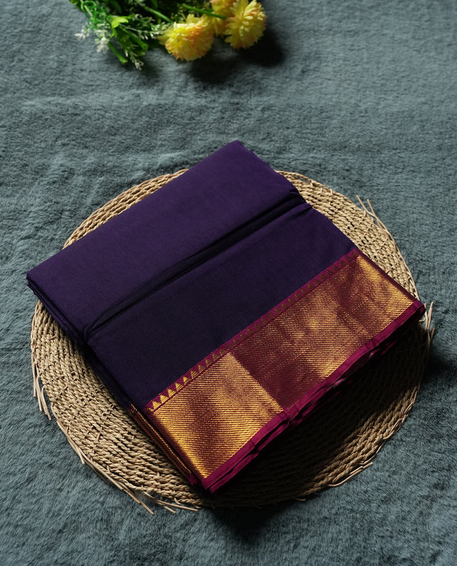 Dark Purple colour Narayanapattu cotton saree featuring a self coloured body, maroon coloured with gold zari pattern border and gold striped colour pallu, pairing a matching blouse piece.