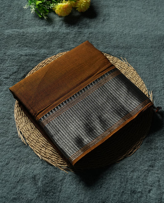 Dark mustard colour Narayanapattu cotton saree featuring a self coloured body, yellow coloured with silver zari pattern border and cream colour pallu, pairing a matching blouse piece.
