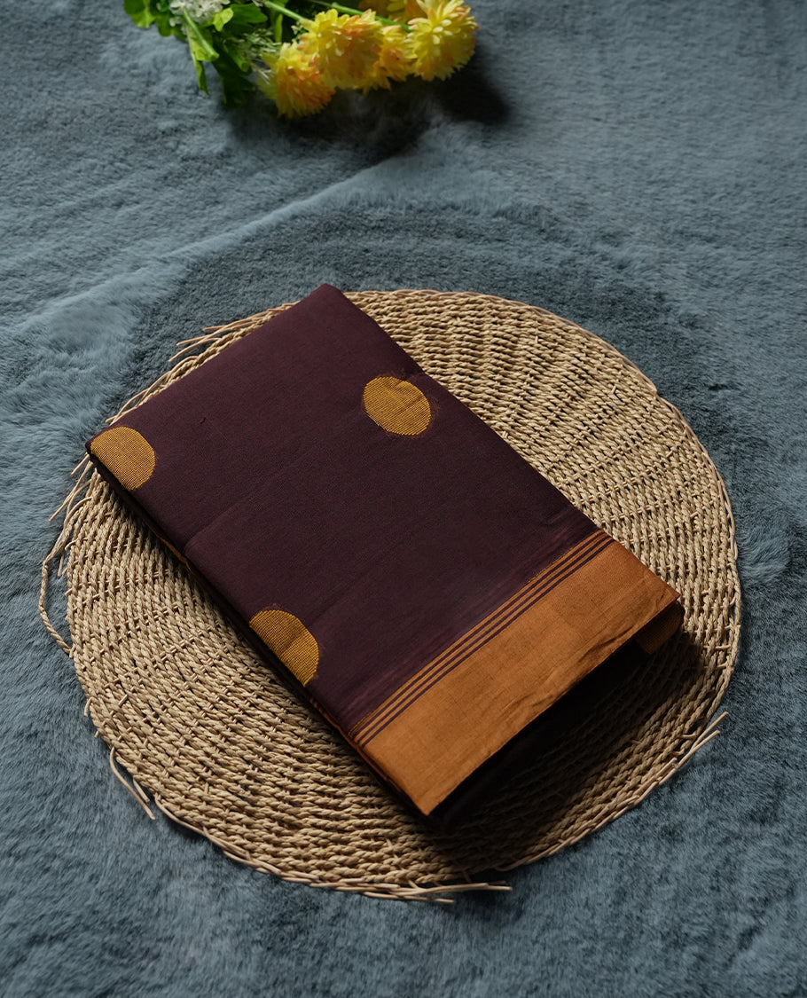 Dark Brown colour Silk Cotton Saree with Mustard Orange Circular Buttas on the Body, Contrasting Antique Gold Zari Pallu Featuring Intricate Floral and Geometric Motifs with Temple-Style Borders, Paired with a Coordinated Blouse Piece