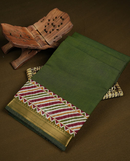 Olive green colour chanderi cotton saree featuring plain body, multicoloured printed geometric border with diagonal stripes, zigzag and floral motifs, golden zari border, and matching striped blouse.