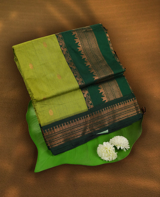Lemon Green colour Kalyani Cotton saree with copper motifs, paired with a contrasting green border featuring intricate zari work & Comes with a matching blouse piece.