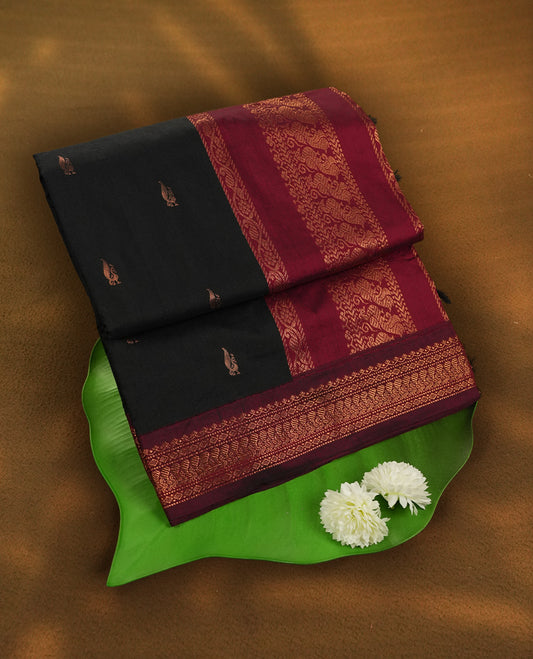 Black colour Kalyani Cotton saree with rich maroon border and pallu, featuring copper zari motifs and intricate weaving & Includes a matching blouse piece.