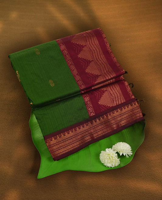 Olive green  colour Kalyani Cotton saree with maroon border and temple motifs on pallu, adorned with copper zari motifs and intricate weaving & Comes with a matching blouse piece.