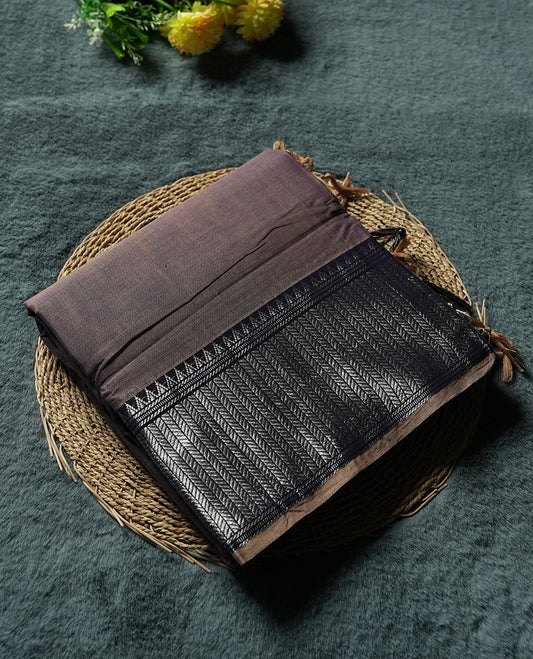 dark purple colour Narayanapattu cotton saree featuring a self coloured body, dark purple coloured with silver zari pattern border and ivory striped colour pallu, pairing a matching blouse piece.