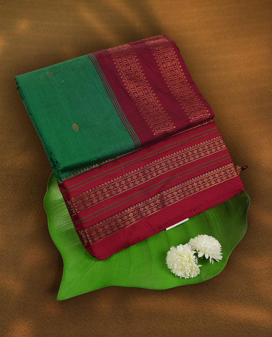 Royal green colour Kalyani cotton saree with contrast maroon border adorned with intricate golden zari weaving & Paired with matching blouse.
