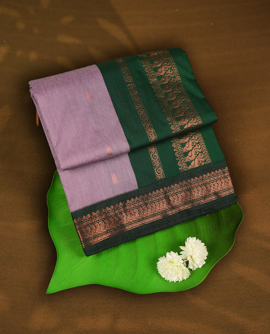 Lavender colour Kalyani Cotton saree with delicate woven zari motifs all over, paired with a contrasting deep green border and pallu intricately woven with rich copper peacock zari & Comes with a matching blouse piece.