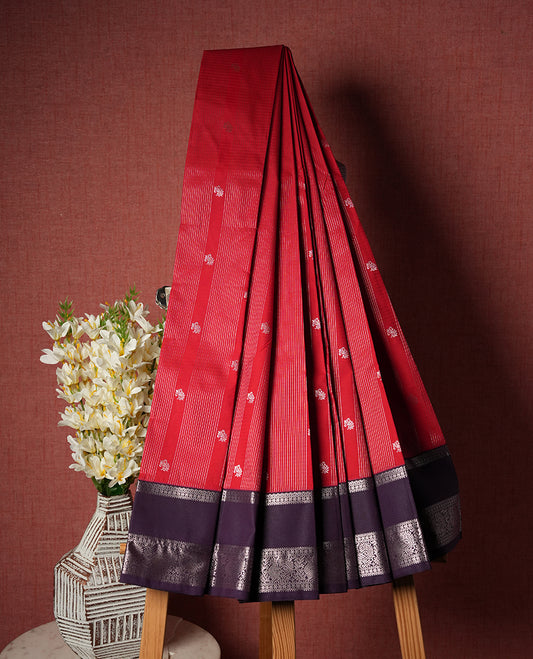 Red colour Semi Silk Saree with rose gold zari patterns on the body, paired with a contrasting Dark violet colour traditional pallu and border, and a matching blouse piece.