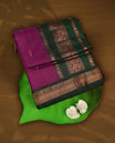 Purple colour Kalyani cotton saree with intricate small motifs all over, paired with a contrasting dark green rich zari woven border and rich peacock worked pallu & Comes with a matching blouse piece