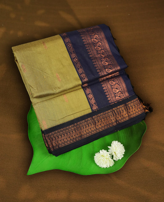 Golden yellow colour Kalyani Cotton saree with subtle zari woven motifs all over, paired with a contrasting deep navy blue rich copper zari border and pallu & Comes with a matching blouse piece.