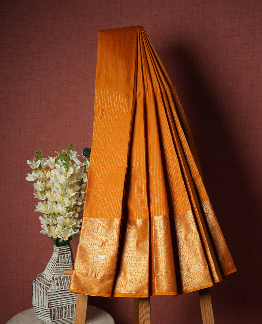 Marigold colour Semi Silk Saree with gold zari striped patterns on the body with self coloured border, paired with a contrasting dark purple colour traditional pallu, and a matching blouse piece.