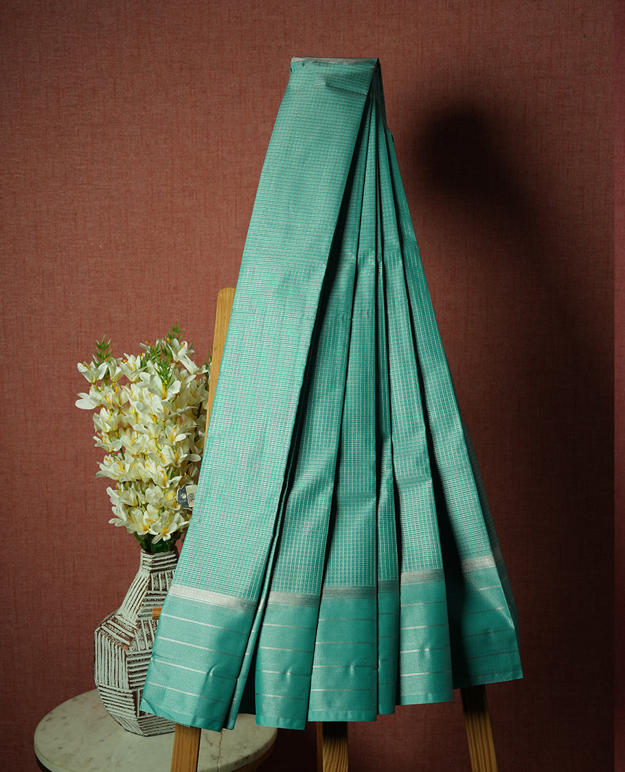 Aqua Green Colour Semi Silk Saree with Silver Checked Body, Self Coloured Silver Zari Pallu & Border, Circular Floral Motifs, and Matching Blouse Piece
