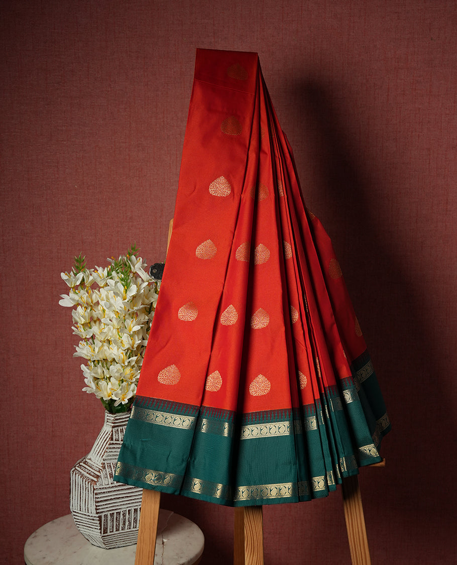 Red orange colour Semi Silk Saree with gold zari patterns on the body, paired with a contrasting Green traditional pallu and border, and a matching blouse piece.