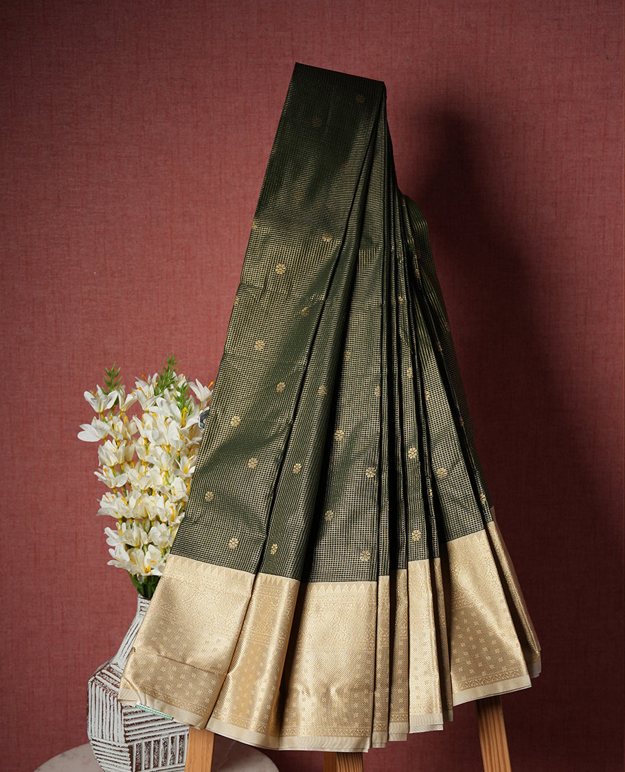 Dark green colour Semi Silk Saree with gold zari striped patterns on the body, paired with a contrasting cream traditional pallu and border, and a matching blouse piece.