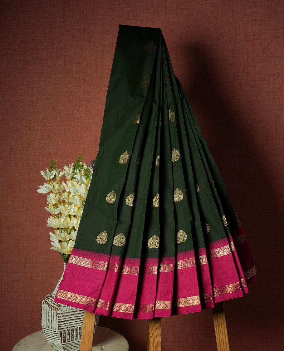 Dark green colour Semi Silk Saree with gold zari patterns on the body, paired with a contrasting rani pink colour traditional pallu and border, and a matching blouse piece.