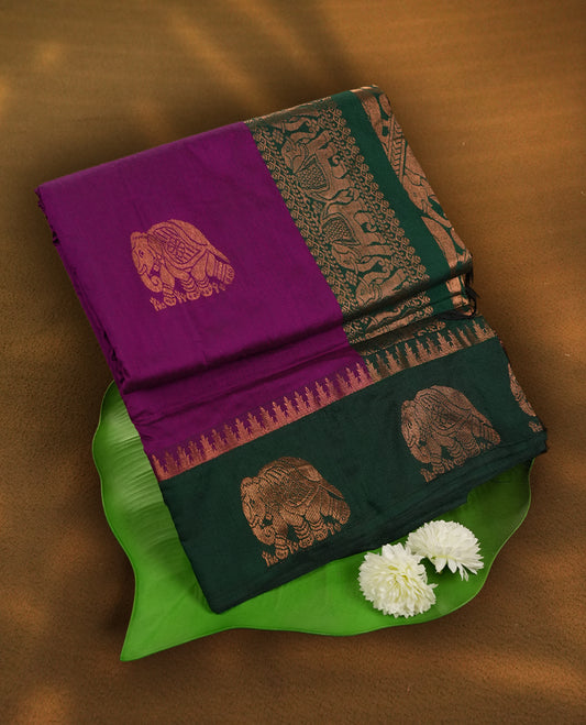 Purple colour Kalayani cotton saree featuring majestic copper zari elephant motifs on the body, paired with a contrasting green border and pallu adorned in intricate traditional designs with matching blouse