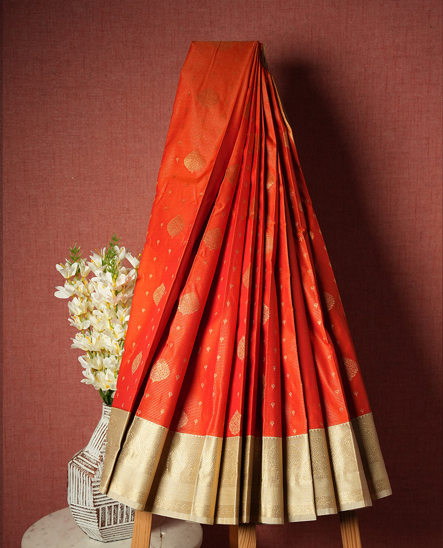Orange colour Semi Silk Saree with gold zari striped patterns on the body, paired with a contrasting Cream colour traditional pallu and border, and a matching blouse piece.