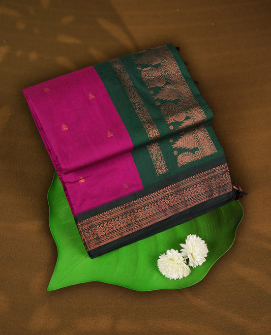 Magenta colour Kalyani cotton saree with intricate small motifs all over, paired with a contrasting green rich peacock & temple zari woven border and pallu & Comes with a matching blouse piece.