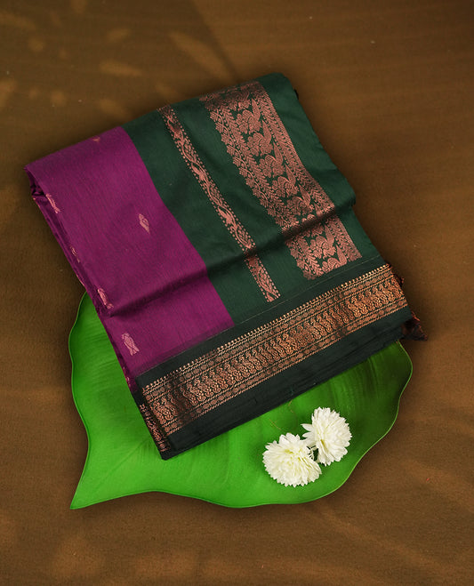 Purple colour Kalyani cotton saree with intricate small motifs all over, paired with a contrasting dark green rich zari woven border and pallu & Comes with a matching blouse piece