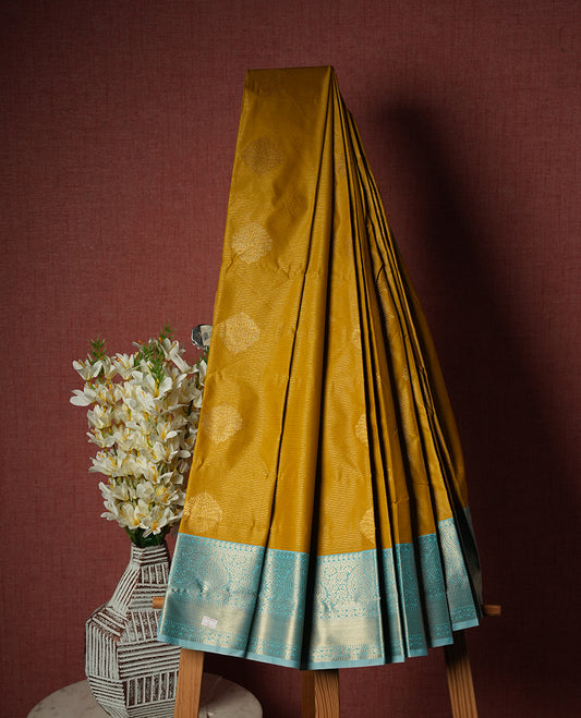 Yellow Semi Silk Saree featuring gold zari motifs on the body, contrasted with a light blue and gold zari pallu and border adorned with traditional motifs, paired with a matching blouse piece.