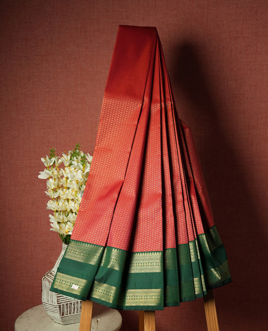 Red colour Semi Silk Saree with gold zari patterns on the body, paired with a contrasting green traditional pallu and border, and a matching blouse piece.
