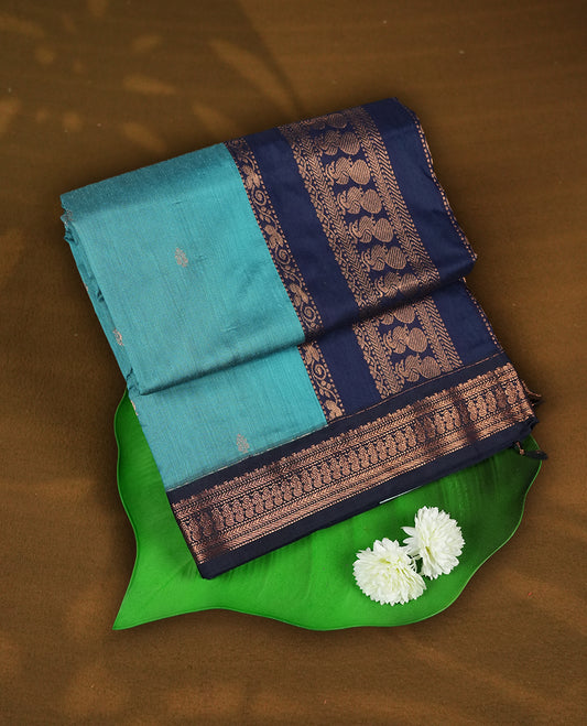 Sky blue colour Kalyani cotton saree with subtle zari motifs all over, paired with a contrasting rich navy blue copper peacock zari woven border and pallu & comes with a matching blouse piece.