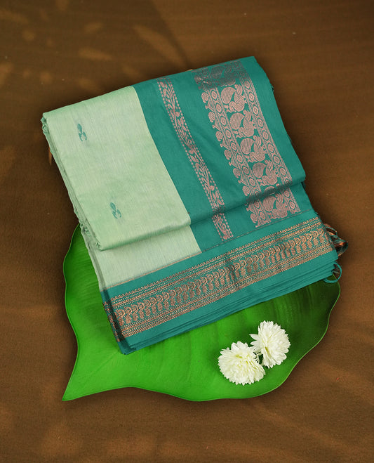 Mint green colour Kalyani cotton saree with subtle zari motifs all over, paired with a contrasting teal green rich copper zari woven border and pallu & Comes with a matching blouse piece.