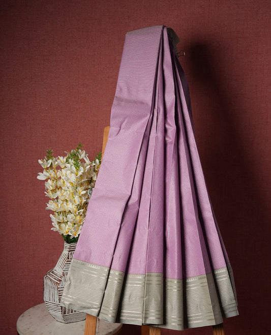 Lavender colour Semi Silk Saree with silver zari striped patterns on the body, paired with a contrasting light gray colour traditional pallu and border, and a matching blouse piece.
