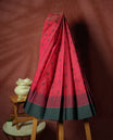 Crimson pink colour silk cotton saree featuring elegant floral zari motifs on the body, complemented by a rich contrast dark plain grey border and pallu with traditional woven detailing & Comes with a matching blouse piece.
