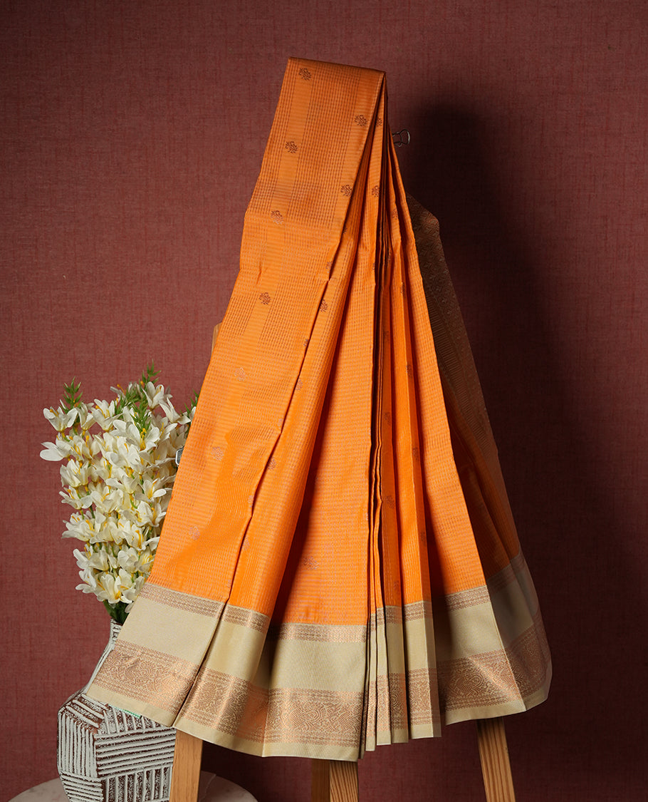 Orange colour Semi Silk Saree with rose gold zari striped patterns on the body, paired with a contrasting cream colour traditional pallu and border, and a matching blouse piece.