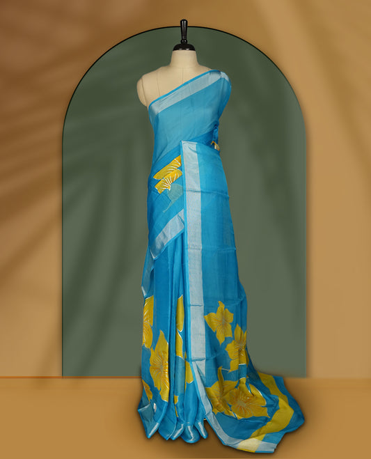 Sky blue colour saree with vibrant yellow floral prints and a soft striped border & Includes matching blouse piece.